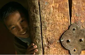 a child smiling behind the door